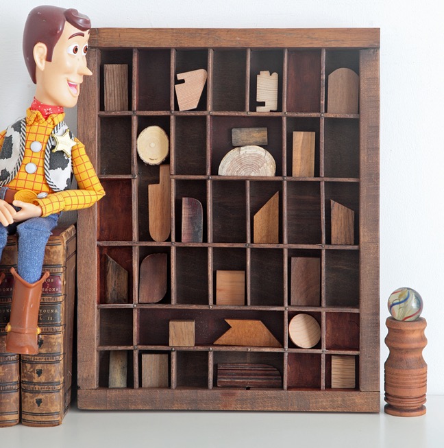 A very woody assemblage art with old wooden block in a re purposed antique letterpress printers tray type case drawer