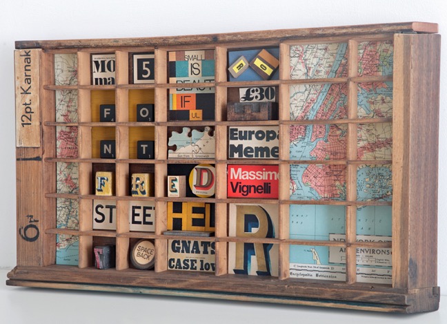 Assemblage artwork with a typographic theme in an old letterpress type case cabinet