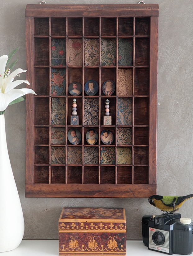 Up Cycled letterpress printers tray used as a decorative display cabinet for William Morris prints and little oval historical portraits and little ornaments 