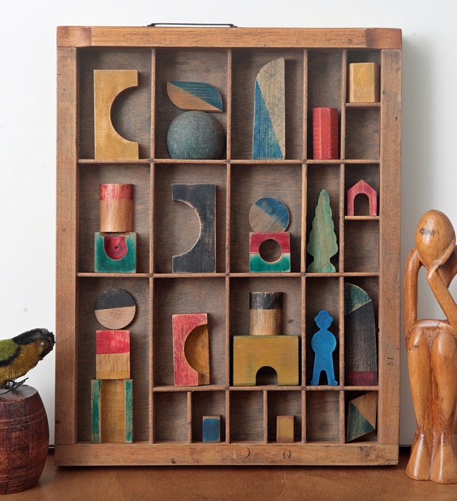 Assemblage artwork of old wooden blocks in a vintage letterpress printers type case drawer tray 