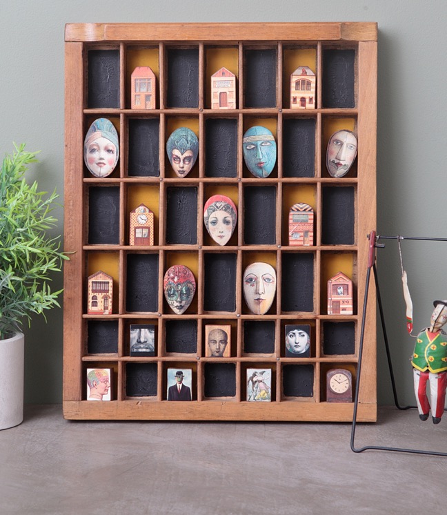 Vintage printers type case re purposed and up cycled as a display of quirky wooden face figures