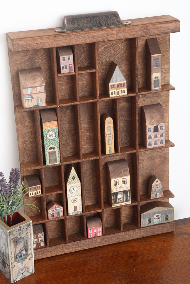 Handmade little wooden vintage houses in old printers tray