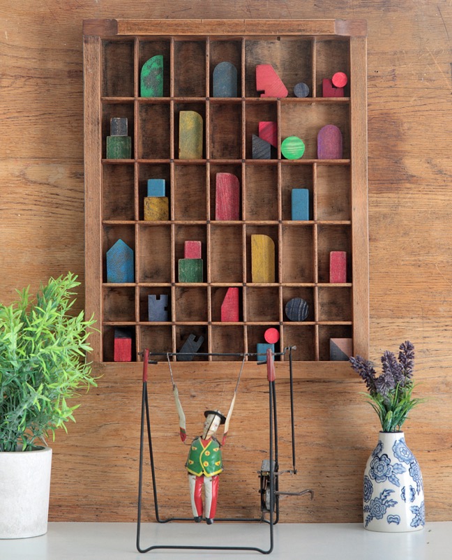 Assemblage artwork of old wooden blocks in an vintage letterpress printers type case drawer tray 