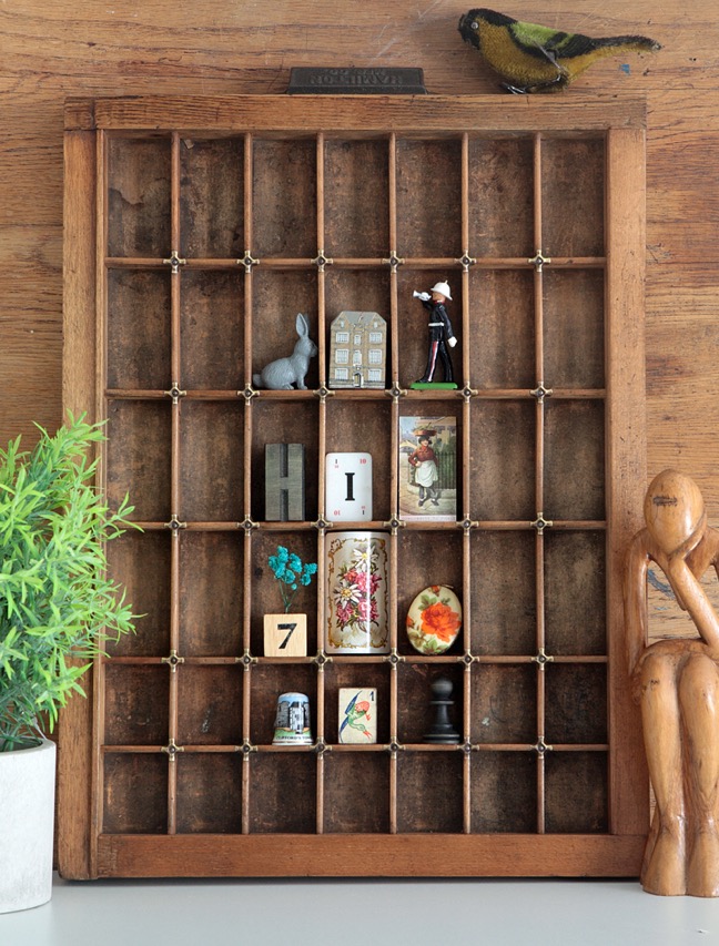 Display of little curios in an old printers type case tray